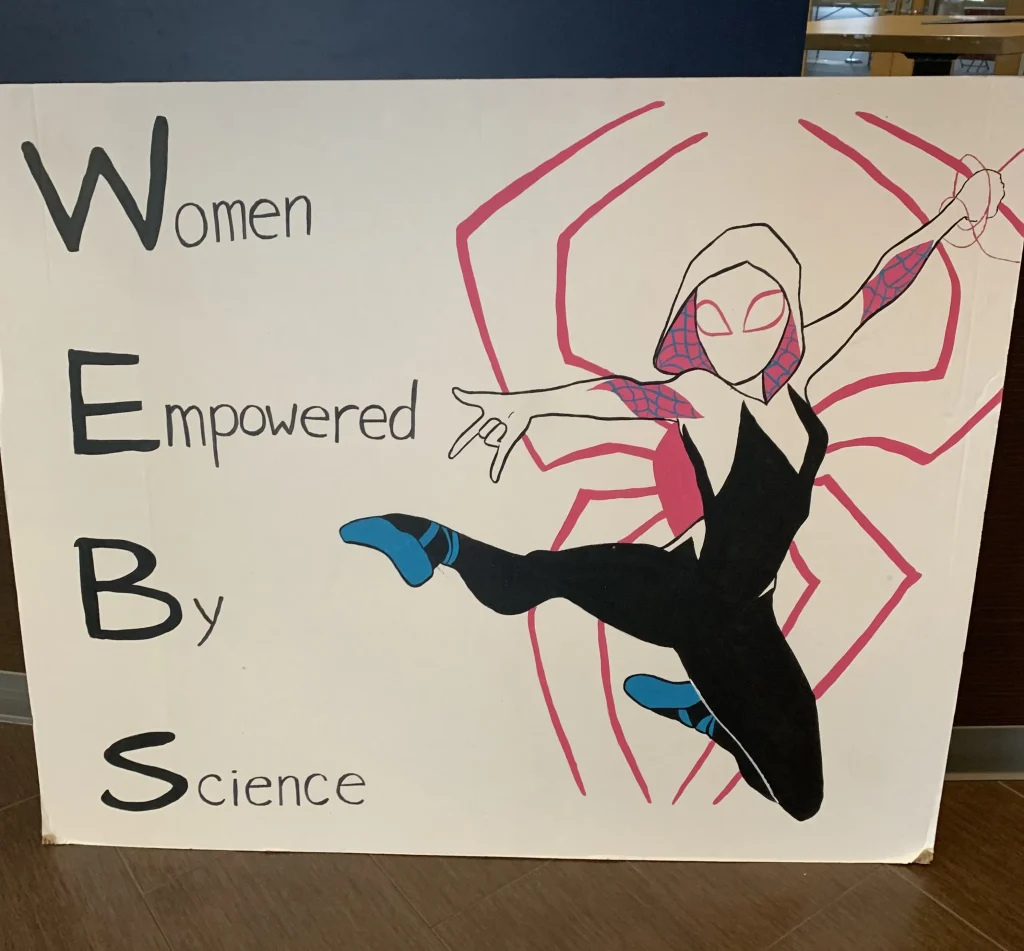 Sign reading Women Empowered By Science featuring SpiderWoman