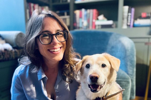 Photo of Catherine Carberry with her dog in front of book shelves
