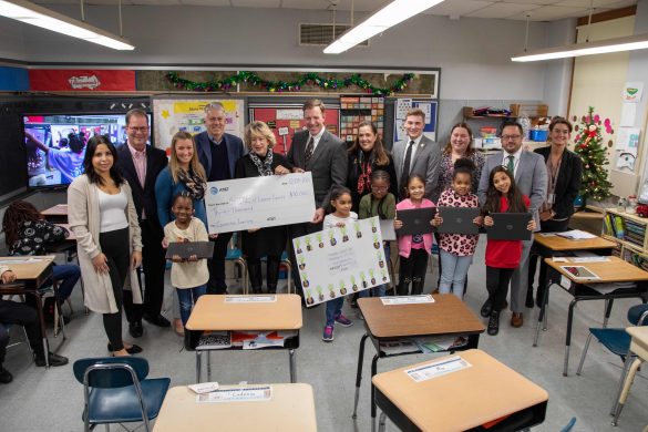 SHINE students, staff and guests gathered around a big check for the AT&T donation presentation