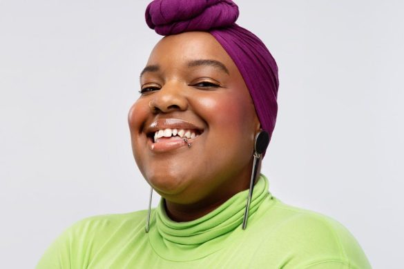photo of leah vernon in a lime green turtleneck and fuschia head wrap