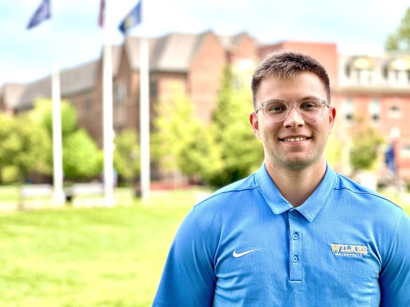 zac gula photo - young man with short hair and glasses with breiseth hall in the background