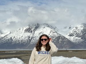 sarah markovich in a wilkes pharmacy sweatshirt in front of snow capped mountains