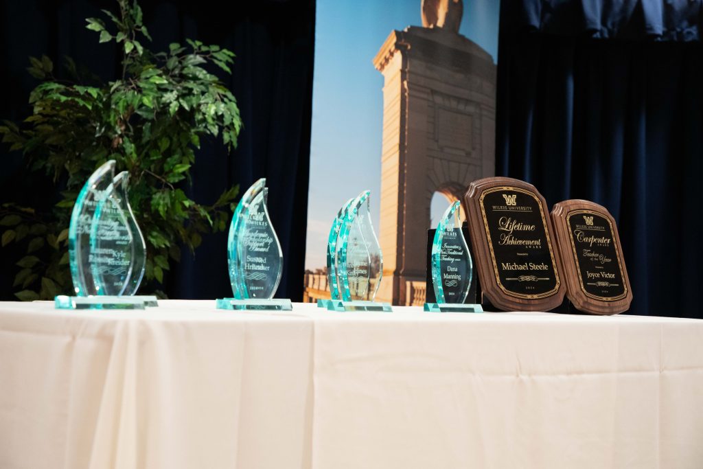 Photo of lucite TREC awards and two wooden plaques on a table 