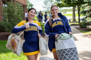 Wilkes cheerleaders help carry new student belongings into Evans Hall