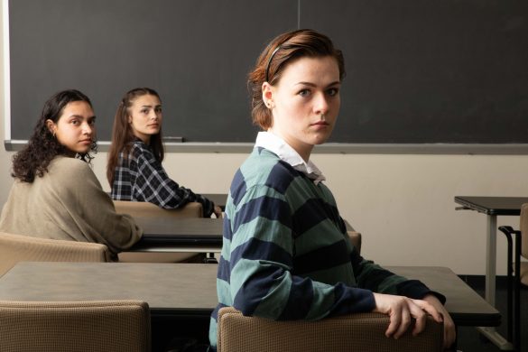 Three young women in high school sitting at desks