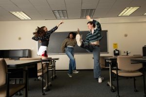 Three female high school students dancing in a classroom