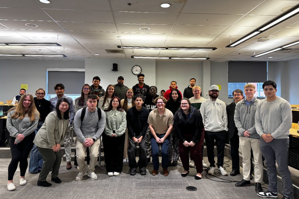 A group photo of students and professors Anna Ma and Jamal  Ghorieshi posing in a classroom 